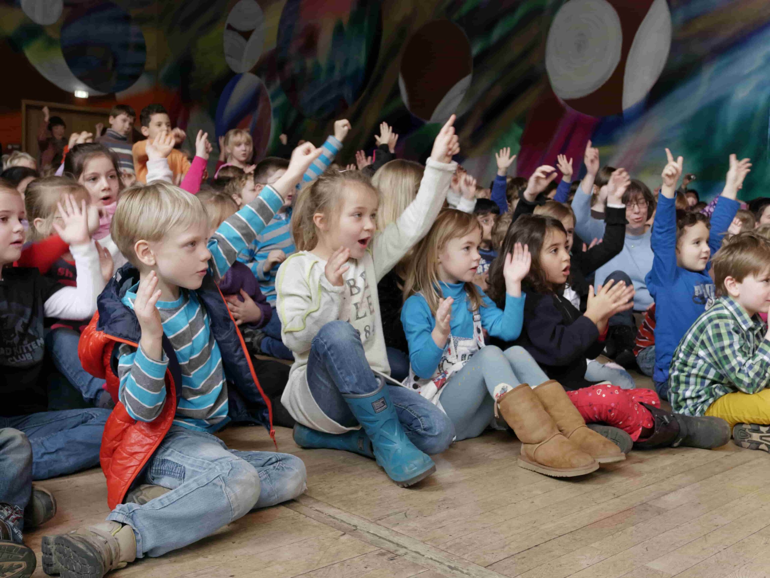 Kinder auf dem Boden der Aula